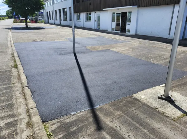 Frisch asphaltierte Fläche vor einem Gewerbegebäude