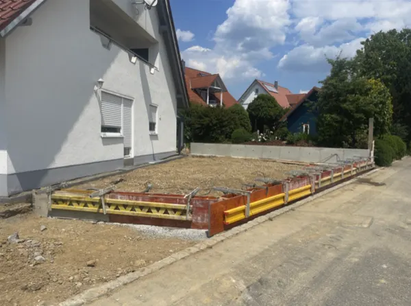 Fundament mit Schalung vor einem Haus